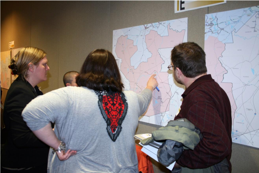 People looking at maps at a public outreach meeting