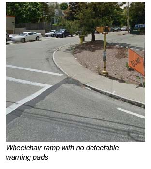 This is a photo of a wheelchair ramp at the intersection that does not have any detectable warning pads.