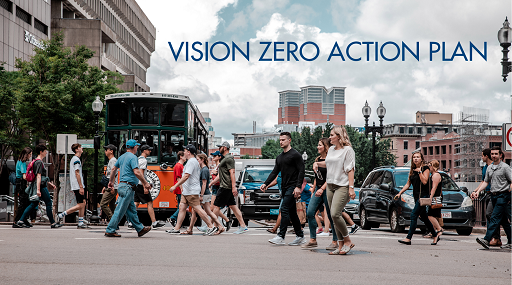 Photograph of about a dozen pedestrian crossing in front of stopped traffic near Boston City Hall