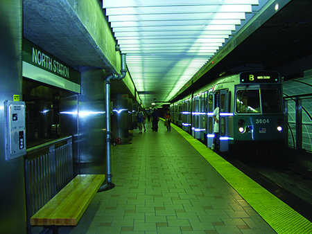 A B Line Green Line train sits on the tracks at North Station. Several people stand on the platform.